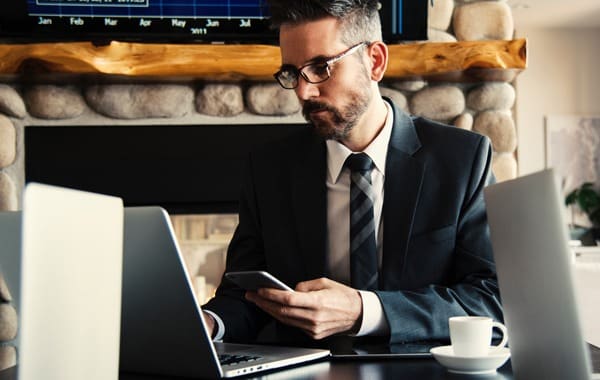 Man in black holding phone while working