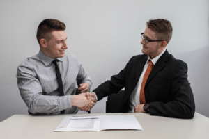 two man shaking hands while smiling